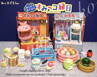 Könnte beinhalten: Ein Set an Sumikko Gurashi-Minispielzeug, darunter ein rosa Zuckerwattestand, ein blauer Eisstand, ein kleines Schwimmbecken mit einem Fisch, eine Wassermelone, eine Trommel und mehrere kleine Sumikko Gurashi-Figuren. Der Text auf den Ständen lautet "Sumikko Festival" und "Sumikko Gurashi".