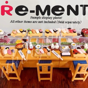 Può includere: Set di ristoranti di sushi in miniatura con bancone in legno, sgabelli e vari piatti di sushi. Il set include rotoli di sushi, nigiri e altri piatti giapponesi. È una foto di esempio.