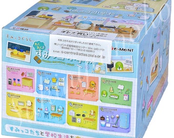 May include: A colorful box featuring illustrations of Sumikko Gurashi characters in a school setting. The box displays various miniature scenes, including classrooms and school supplies. The text on the box includes Japanese characters and the words "Sumikko Elementary School."