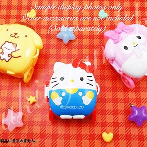 May include: Three small, wheeled, character-shaped luggage sets. The luggage is yellow with a brown dog character, pink with a white rabbit character, and blue with a white cat character. The luggage is on a red and white checked background.