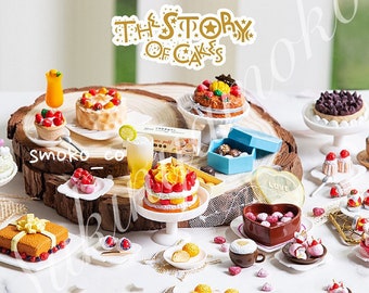 May include: A miniature cake display featuring an assortment of cakes, pastries, and desserts. The cakes are decorated with fruit, chocolate, and other toppings. The display is set on a wooden base and includes a sign that reads "The Story of Cakes".