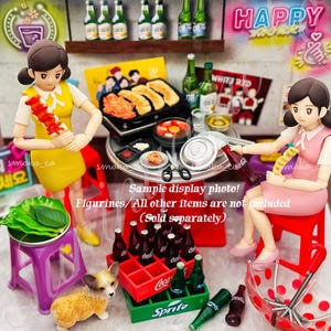 May include: A miniature Korean BBQ restaurant playset featuring two figures, a grill, a table with food, and a selection of drinks. The set includes a red and green Coca-Cola crate, a green Sprite crate, and a purple stool. The set also includes a small dog figurine.