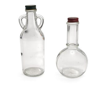 May include: Two clear glass bottles with dark green and maroon caps. One bottle has a handle on each side, and the other has a round base and a long neck. Both bottles are empty and sit on a white background.