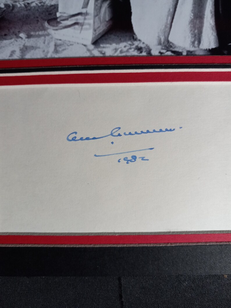 May include: A white card with a blue ink signature that reads "Cesar Chavez" and the year "'62" underneath.