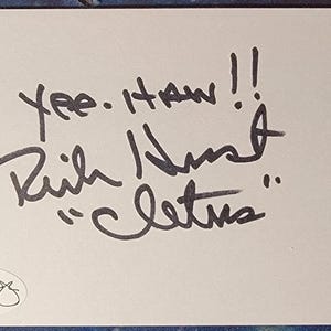 May include: A white card with black handwritten text that reads "Yee-Haw!! Rich Hunt 'Cletus'" and a signature. The card also has a small number "1/1" in the bottom right corner.