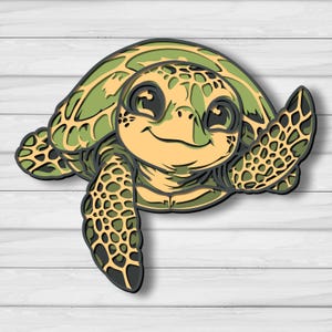 Puede incluir: Un diseño de tortuga marina de madera en capas en tonos verdes, beige y negro. La tortuga tiene una cara sonriente y aletas extendidas, dando una apariencia amigable. El diseño está sobre un fondo blanco con vetas de madera.