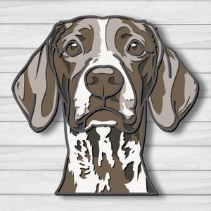 May include: A layered paper art piece depicting a German Shorthaired Pointer dog. The dog's head is rendered in shades of brown, white, and gray, with a detailed, three-dimensional effect. The background is a white, wood-grain texture.