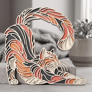 May include: A multi-layered wooden wall art piece depicting a stretching cat. The design features intricate, stacked cutouts in shades of black, orange, and cream, creating a dimensional effect that highlights the feline's arched back and tail.