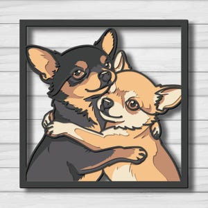Op de afbeelding: Een gelaagd wandkunstwerk met een zwart-bruine Chihuahua die een lichtbruine Chihuahua knuffelt. De twee honden zijn afgebeeld in een gestileerd, multidimensionaal ontwerp, ingesloten in een dun zwart vierkant frame met gedetailleerde uitsparingen.