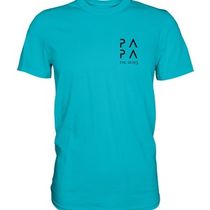 May include: A turquoise blue t-shirt with a black logo that says "PA PA" and "est. 2023".