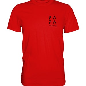May include: Red t-shirt with a black logo that says "PA PA" and "est. 2023".
