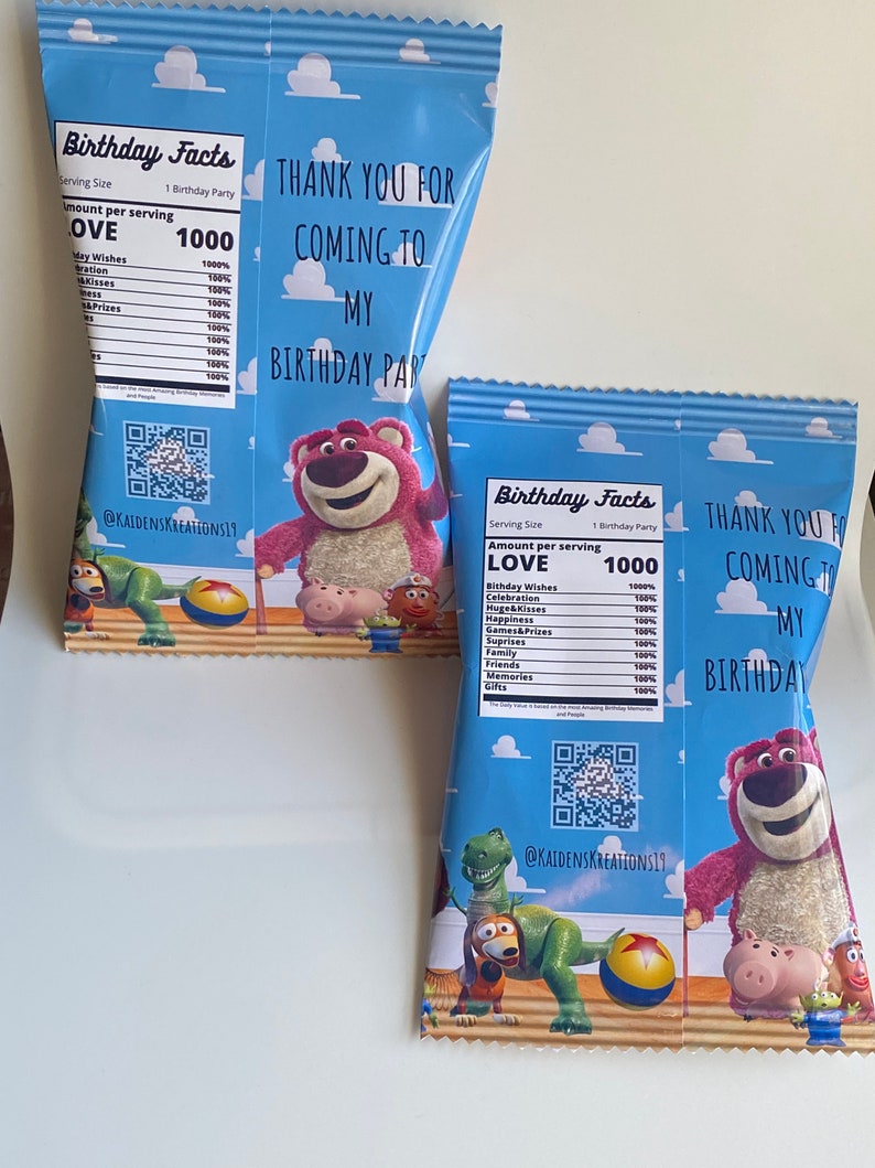 Puede incluir: Dos bolsas de regalo azules y blancas con tem&aacute;tica de Toy Story. Las bolsas presentan una imagen de dibujos animados de Woody, Buzz Lightyear, Rex y otros personajes de la pel&iacute;cula. Las bolsas tienen una etiqueta que dice "Birthday Facts" y enumera diferentes cosas como "Love" y "Birthday Wishes" con una cantidad de 1000. Las bolsas tambi&eacute;n tienen un c&oacute;digo QR y el texto "@KAIDENSKREATIONS19".