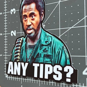 May include: A sticker featuring a man in a green military uniform with the text "U.S. ARMY" on his chest. He is looking at the camera with a questioning expression. The text "ANY TIPS?" is printed in white letters on a black background.