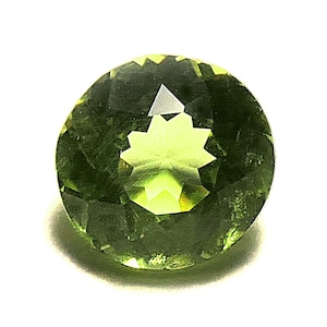May include: A round, faceted, green gemstone with a star-shaped pattern in the center.
