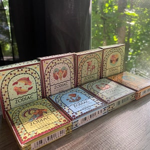 May include: A set of 10 Zodiac incense cones in colorful boxes with astrological symbols. Each box contains 16 incense cones and features a different zodiac sign and scent. The scents include Rose, Sandalwood, Lotus, and more.