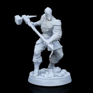 May include: A light gray unpainted miniature figurine of a warrior in plate armor, wearing a helmet and holding a large war hammer with a spiked head. The figure stands in a dynamic combat pose on a circular base textured with rocky terrain.