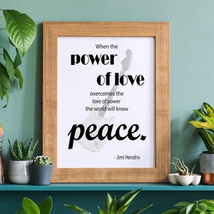 Op de afbeelding: Een ingelijst print met een citaat van Jimi Hendrix: "Wanneer de kracht van de liefde de liefde voor macht overwint, zal de wereld vrede kennen."