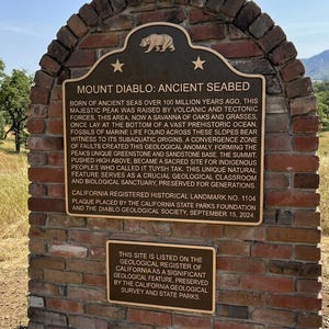 Puede incluir: Un monumento de ladrillo con dos placas de bronce. La placa superior se titula MOUNT DIABLO: ANCIENT SEABED y detalla la historia geol&oacute;gica del pico. La placa inferior m&aacute;s peque&ntilde;a indica que el sitio figura en el registro geol&oacute;gico.
