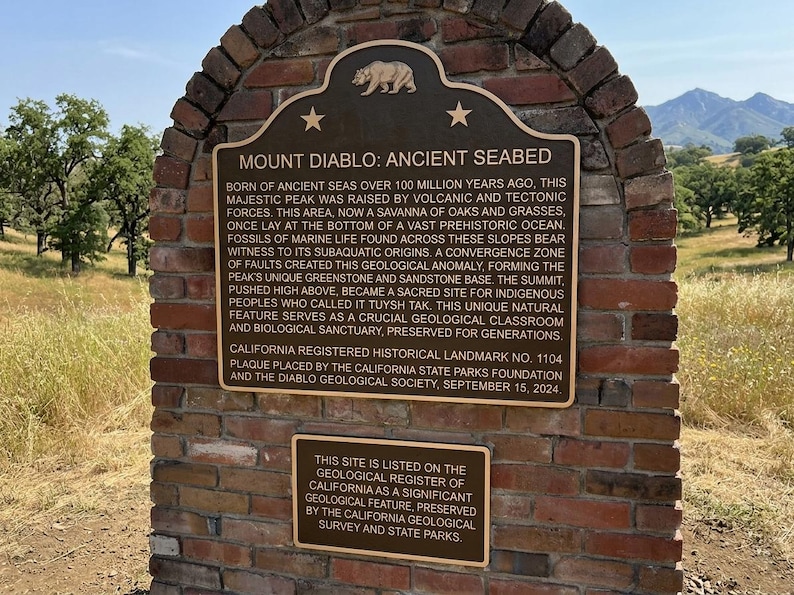 Puede incluir: Un monumento de ladrillo con dos placas de bronce. La placa superior se titula MOUNT DIABLO: ANCIENT SEABED y detalla la historia geol&oacute;gica del pico. La placa inferior m&aacute;s peque&ntilde;a indica que el sitio figura en el registro geol&oacute;gico.