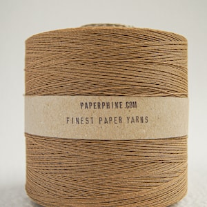 Può includere: Un rocchetto di filo di carta marrone con il testo "PAPERPHINE.COM FINEST PAPER YARNS" sull'etichetta.