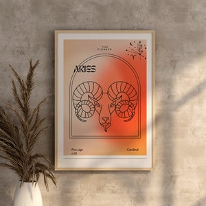 May include: A framed print with a red and orange gradient background featuring a line drawing of an Aries zodiac sign. The text "Aries" is in black lettering and the text "The Pioneer" is in smaller black lettering. The text "Fire sign no. 01" and "Cardinal" are also in black lettering.