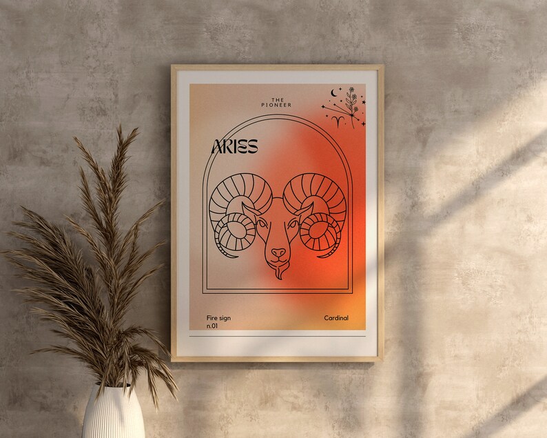 May include: A framed print with a red and orange gradient background featuring a line drawing of an Aries zodiac sign. The text "Aries" is in black lettering and the text "The Pioneer" is in smaller black lettering. The text "Fire sign no. 01" and "Cardinal" are also in black lettering.