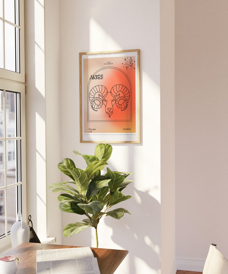 May include: A framed print with a minimalist design featuring the zodiac sign Aries. The background is a gradient of orange and red. The text "Aries" is in black and the text "The Pioneer" is in white. The text "Fire sign" and "Cardinal" are also included.