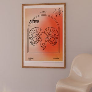 May include: A framed poster with a red and orange gradient background featuring a line drawing of an Aries zodiac sign. The text "Aries" is in black at the top of the poster. The text "The Pioneer" is in black at the top of the poster. The text "Fire sign n.01" is in black at the bottom left of the poster. The text "Cardinal" is in black at the bottom right of the poster.