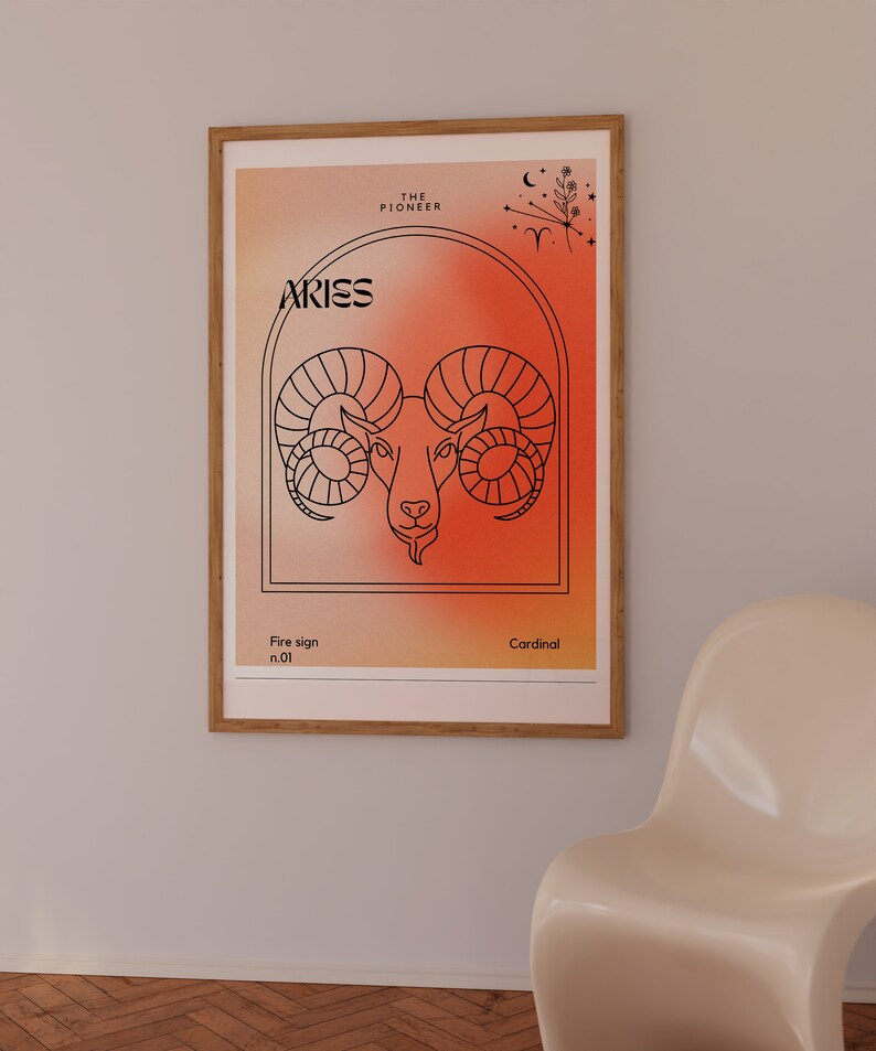 May include: A framed poster with a red and orange gradient background featuring a line drawing of an Aries zodiac sign. The text "Aries" is in black at the top of the poster. The text "The Pioneer" is in black at the top of the poster. The text "Fire sign n.01" is in black at the bottom left of the poster. The text "Cardinal" is in black at the bottom right of the poster.