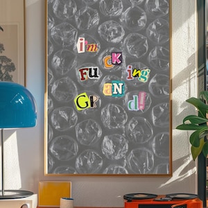 May include: Framed artwork with a bubble wrap background and the words "I'm Fucking Grand!" in cut-out letters. The artwork is displayed in a room with a record player and other decor.