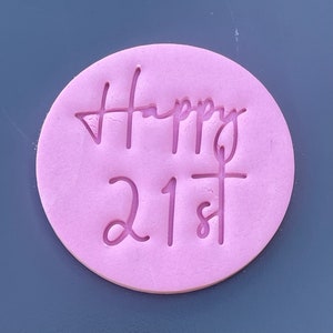 Op de afbeelding: Roze ronde siliconen mal met de woorden "Happy 21st" in reliëf op het oppervlak.