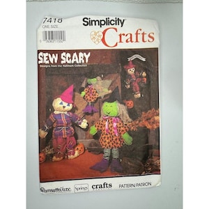 May include: A Simplicity Crafts sewing pattern titled "Sew Scary" featuring Halloween-themed doll designs. The pattern cover displays images of a scarecrow, witch, and other festive characters. The pattern is one size.