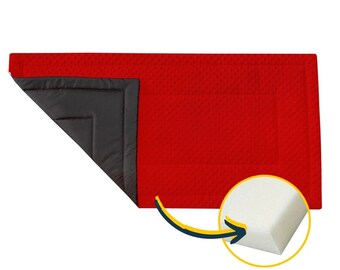 May include: A red rectangular pet bed with a textured surface and a dark gray interior. The corner is folded back to reveal the gray interior. A close-up shows the white foam padding.