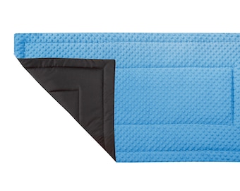 May include: A blue and black quilted baby blanket with a textured surface. The blanket is folded in half, showing the black side.