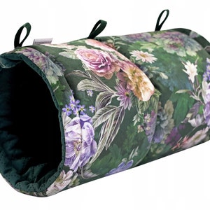 May include: A green and floral patterned pet tunnel with a dark green interior. The tunnel is made of soft fabric and has two loops at the ends for hanging.