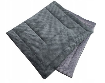 May include: A gray pet bed with a soft, textured surface. The bed is made of two layers of fabric, one with a quilted pattern and the other with a smooth, plush surface.