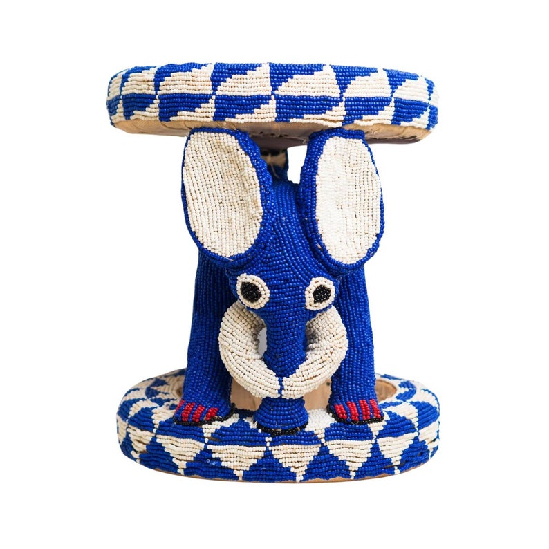 May include: A blue and white beaded elephant stool. The elephant is sitting on a round base with a blue and white beaded design.