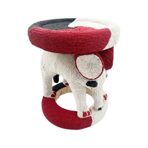 Peut inclure: Un tabouret en forme d'éléphant recouvert de perles rouges, blanches et noires. Le tabouret est fait de petites perles rondes.