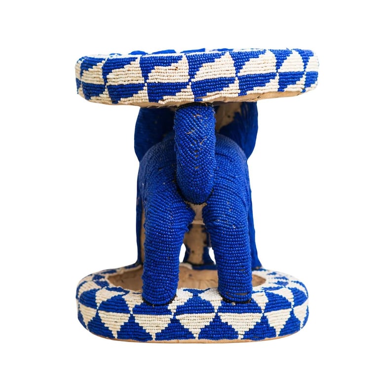 May include: A blue and white beaded stool shaped like an elephant. The stool has a round top and a base with a geometric pattern.