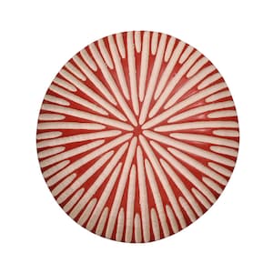 May include: A circular decorative plate with a red and white striped design. The plate has a central pattern that fans outwards, with alternating red and white segments. The plate is likely made of ceramic or wood.