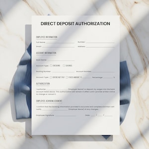 May include: A white Direct Deposit Authorization form with black text. The form includes sections for employee and account information, authorization, and acknowledgment. The form is on a marble-patterned surface.