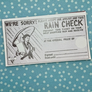 May include: A black and white rain check coupon with the text "We're Sorry! Please accept our apology and this Rain Check. Present this ticket on your next shopping trip and receive at the special price of."  The coupon features a cartoon image of a woman holding an umbrella and packages.