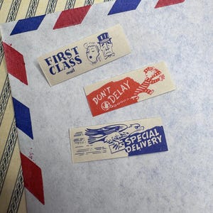 May include: Three vintage-style postage labels on a patterned background. The labels read "FIRST CLASS mail", "DON'T DELAY", and "SPECIAL DELIVERY". Each label features illustrations and is in shades of blue, red, and beige.