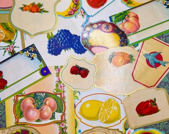 May include: A collection of vintage-style labels featuring colorful illustrations of fruits and berries. The labels have decorative borders and are in various shapes, including shields and ovals. Fruits include apples, lemons, strawberries, and peaches.