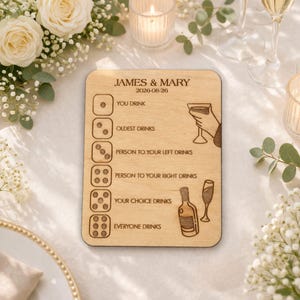 A wooden sign with text and illustrations, placed on a table with white flowers and candles.