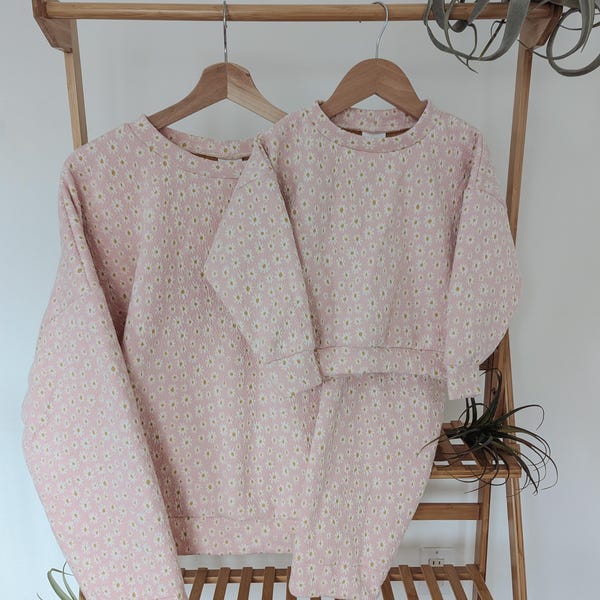 Suéter y pantalones acampanados con estampado de margaritas ruborizadas a juego para bebé, niño pequeño y mamá (se venden por separado)