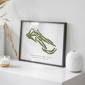 May include: A black framed print of a green golf course map with the text "FOREST HILLS GOLF CLUB, ATLANTA, GEORGIA, USA, PAR 72, 18 HOLES, 7,247 YARDS"
