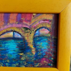 K&ouml;nnte beinhalten: Abstrakte Malerei in einem gelben Rahmen. Das Kunstwerk zeigt eine lebendige Mischung aus Farben, darunter Blau, Rosa und Gelb, die eine traumhafte Landschaft schaffen. Der Stil des Gem&auml;ldes ist impressionistisch, mit sichtbaren Pinselstrichen und einem Fokus auf Farbe und Licht.