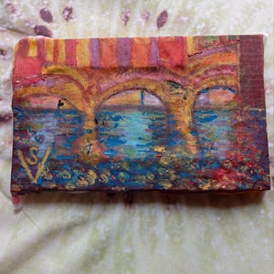 K&ouml;nnte beinhalten: Ein kleines, rechteckiges Gem&auml;lde, das eine Br&uuml;cke &uuml;ber Wasser darstellt. Das Kunstwerk zeigt gew&ouml;lbte Strukturen in Orange- und Gelbt&ouml;nen mit einer blau-t&uuml;rkisfarbenen Wasserszene darunter. Das Gem&auml;lde hat ein strukturiertes Aussehen und eine Signatur in der linken unteren Ecke.