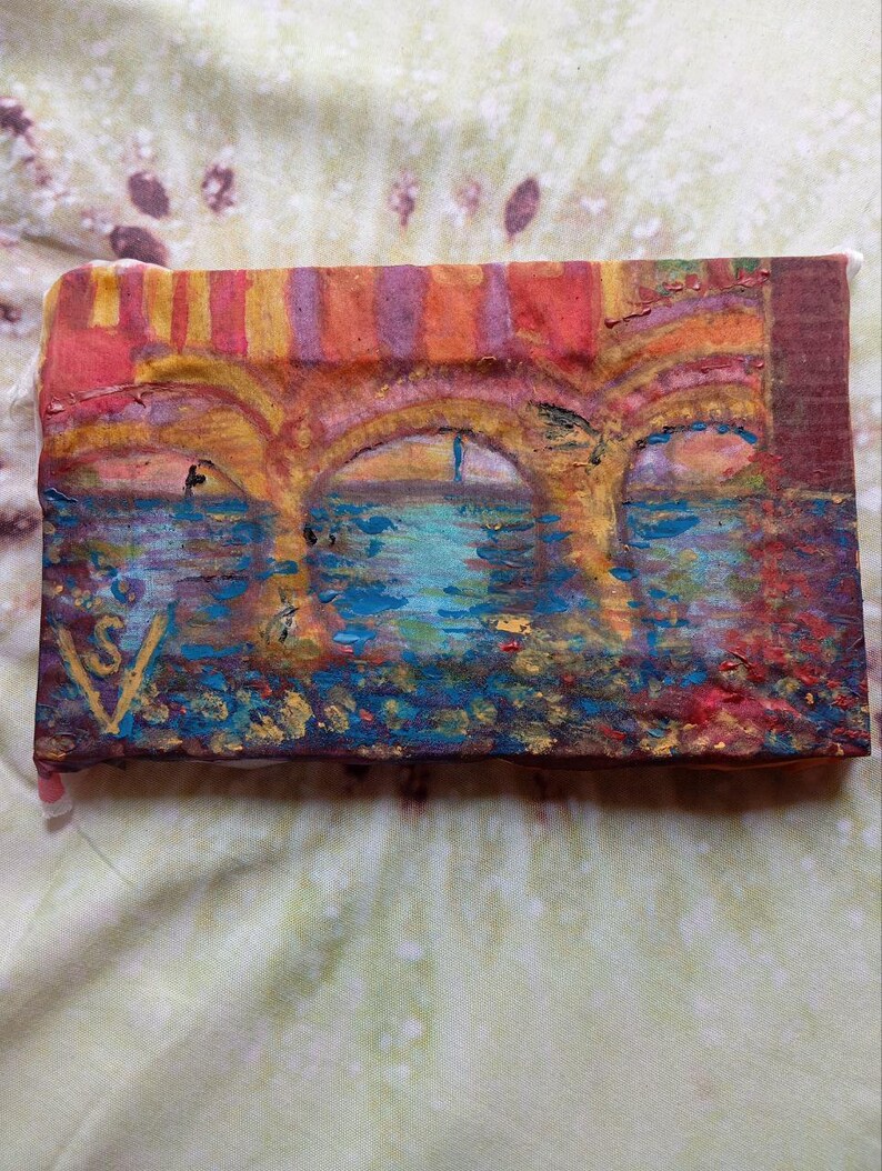 K&ouml;nnte beinhalten: Ein kleines, rechteckiges Gem&auml;lde, das eine Br&uuml;cke &uuml;ber Wasser darstellt. Das Kunstwerk zeigt gew&ouml;lbte Strukturen in Orange- und Gelbt&ouml;nen mit einer blau-t&uuml;rkisfarbenen Wasserszene darunter. Das Gem&auml;lde hat ein strukturiertes Aussehen und eine Signatur in der linken unteren Ecke.